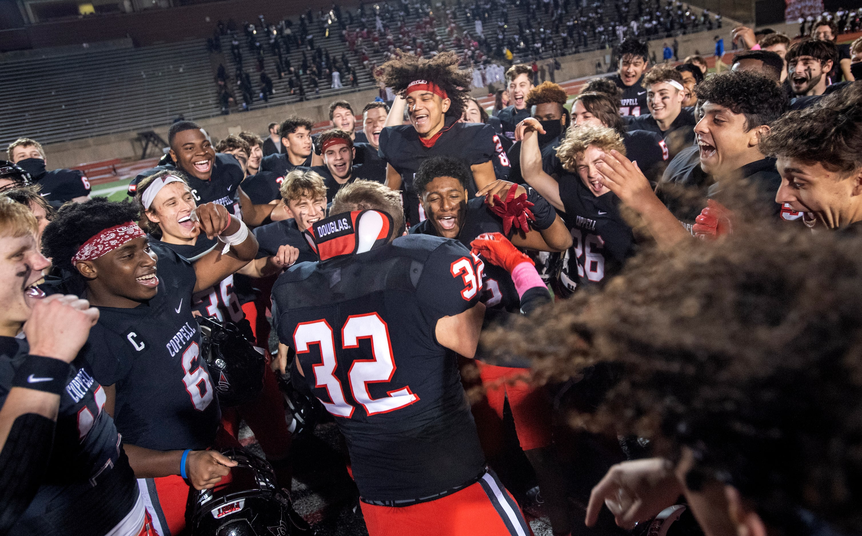 Coppell players celebrate at midfield after defeating Plano West 31-20 in a high school...