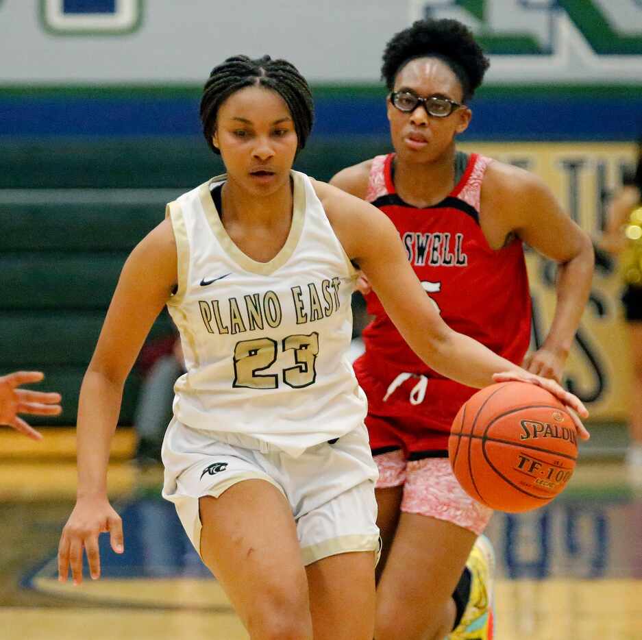 Plano East High School forward Donavia Hall (23) dribbles ahead of Denton Braswell High...