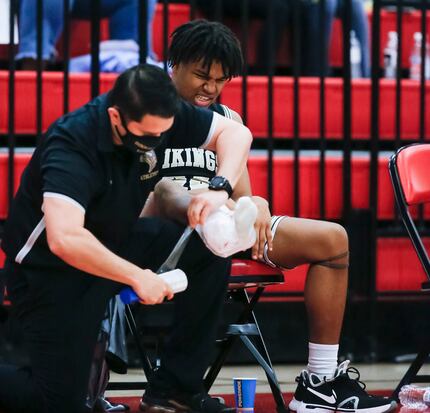 A trainer wraps ice onto Dallas Pinkston Ronald Bridgewater’s right ankle after an injury...