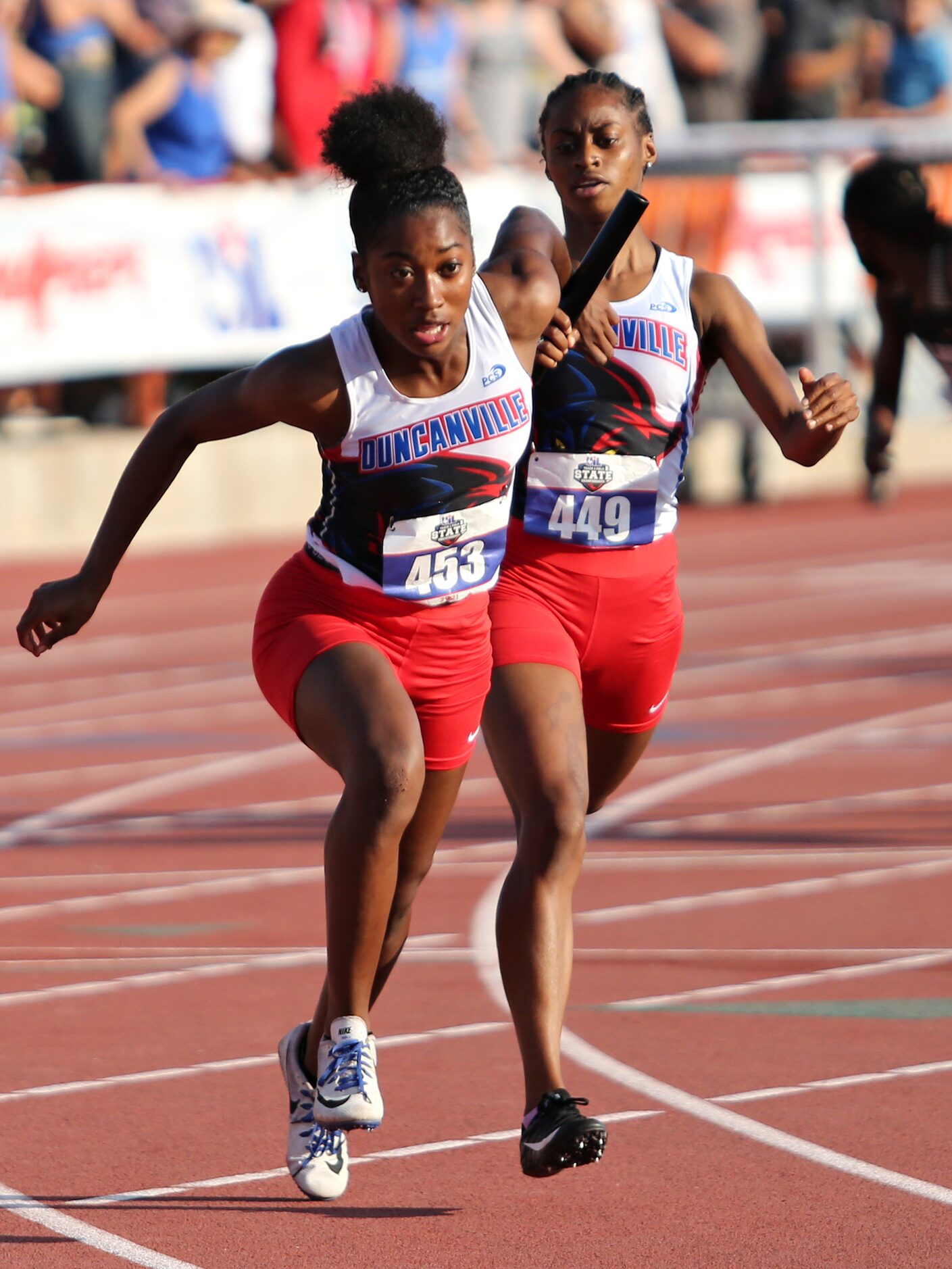 Duncanville's Laroncia Alexander hands off the baton to teammate Makhiya McDonald during...