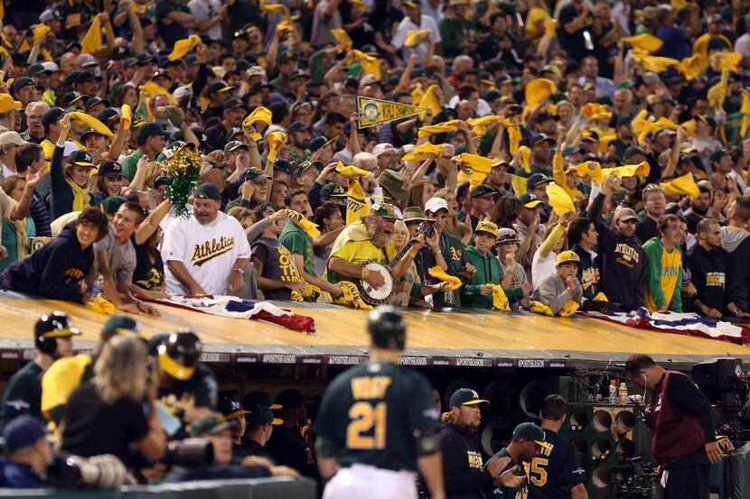 Oct 4, 2013; Oakland, CA, USA; Oakland Athletics fans celebrate above the dugout after a two...