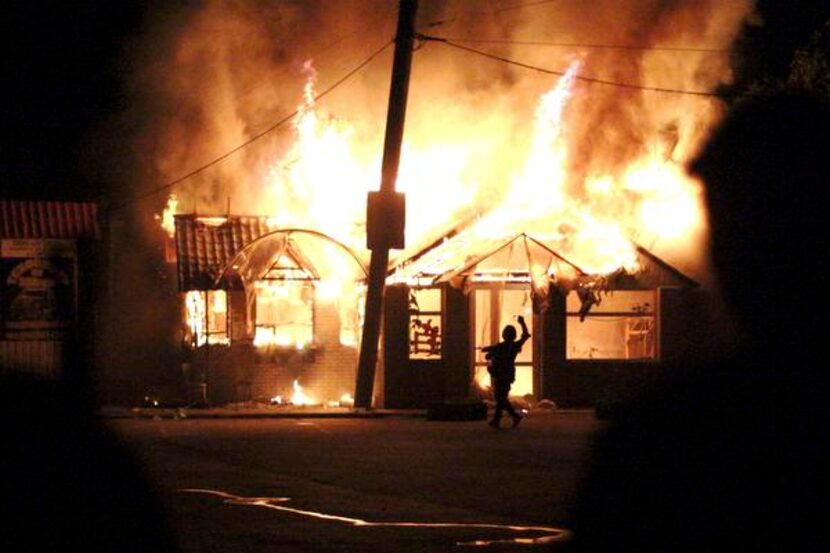 
A pro-Russian fighter takes a cellphone photo of a burning cafe struck by a mortar bomb in...