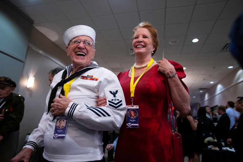 Navy veteran Don Fraser is escorted by daughter Diana Keller as he and more than 60 other...