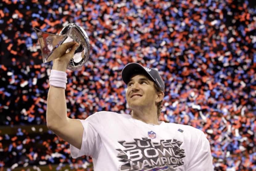 New York Giants quarterback Eli Manning holds up the Vince Lombardi Trophy while celebrating...