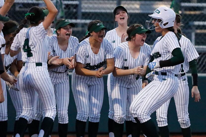 Prosper High School Gabby Coffey (10) is greeted by team mates at home plate after hitting...