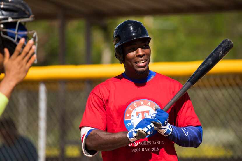 Cuban outfield Julio Pablo Martinez hits in a tryout game during a camp at the Rangers'...