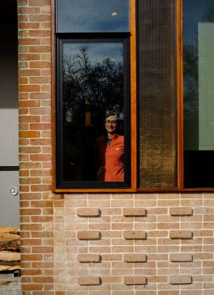 Lea Bauman in the front window of her house in Cochran Heights.