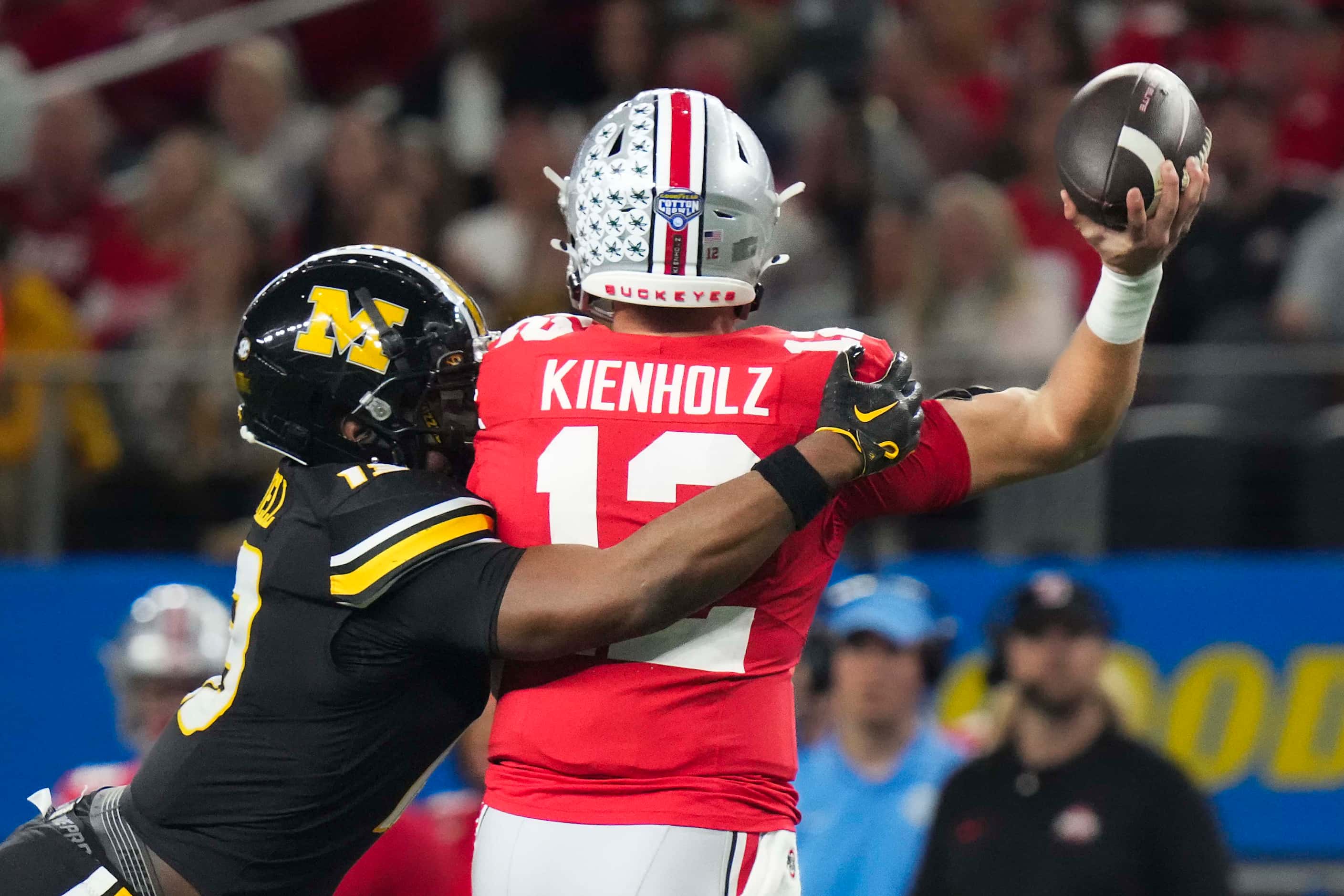 Ohio State quarterback Lincoln Kienholz (12) gets off a pass as he is hit by Missouri...