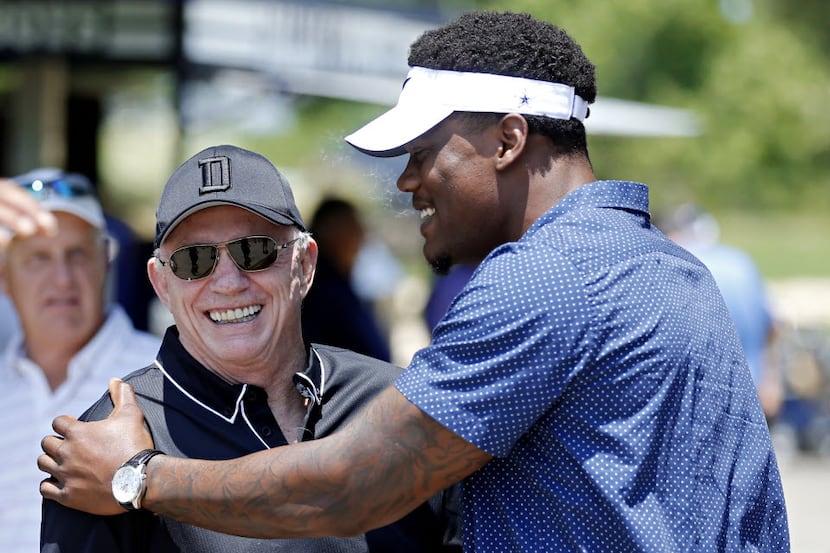 Dallas Cowboys owner Jerry Jones (center) talks with defensive end Randy Gregory during the...