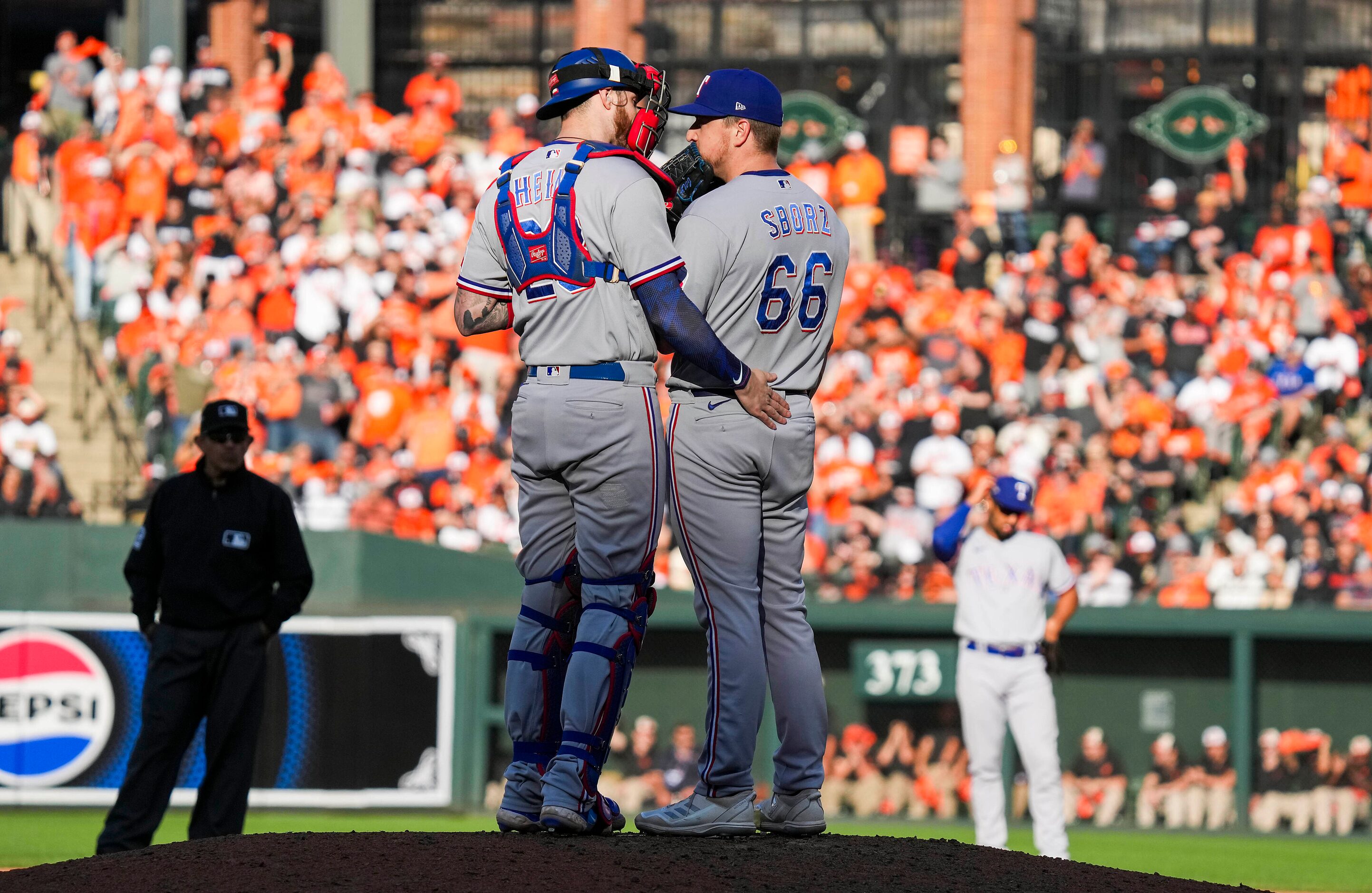 Texas Rangers relief pitcher Josh Sborz (66) gets a visit from catcher Jonah Heim (28)during...