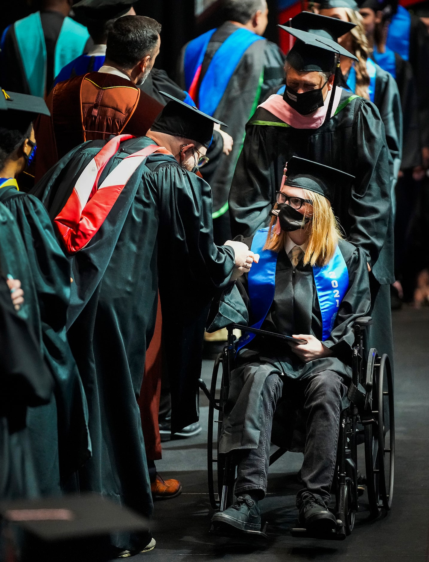 Korbin Bilbrey crosses the stage in a wheelchair to receive his diploma during commencement...