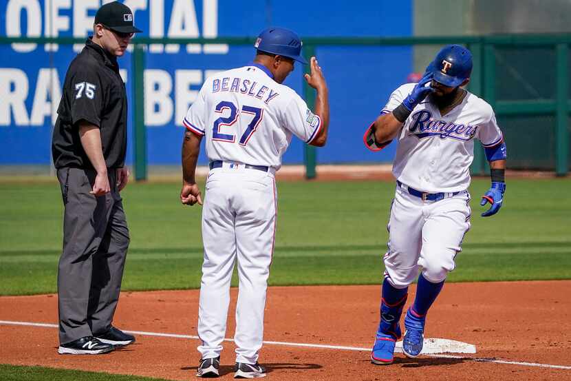 Texas Rangers third base coach Tony Beasley salutes second baseman Rougned Odor as he rounds...