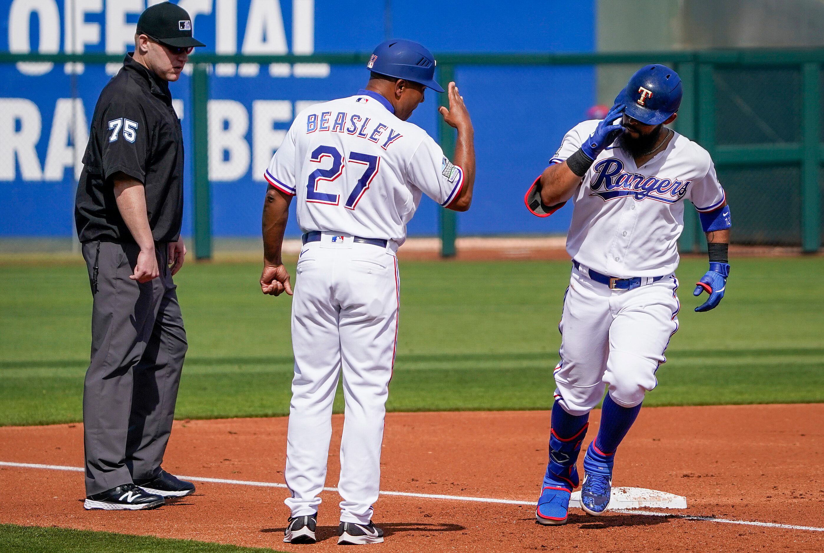 Texas Rangers third base coach Tony Beasley salutes second baseman Rougned Odor as he rounds...