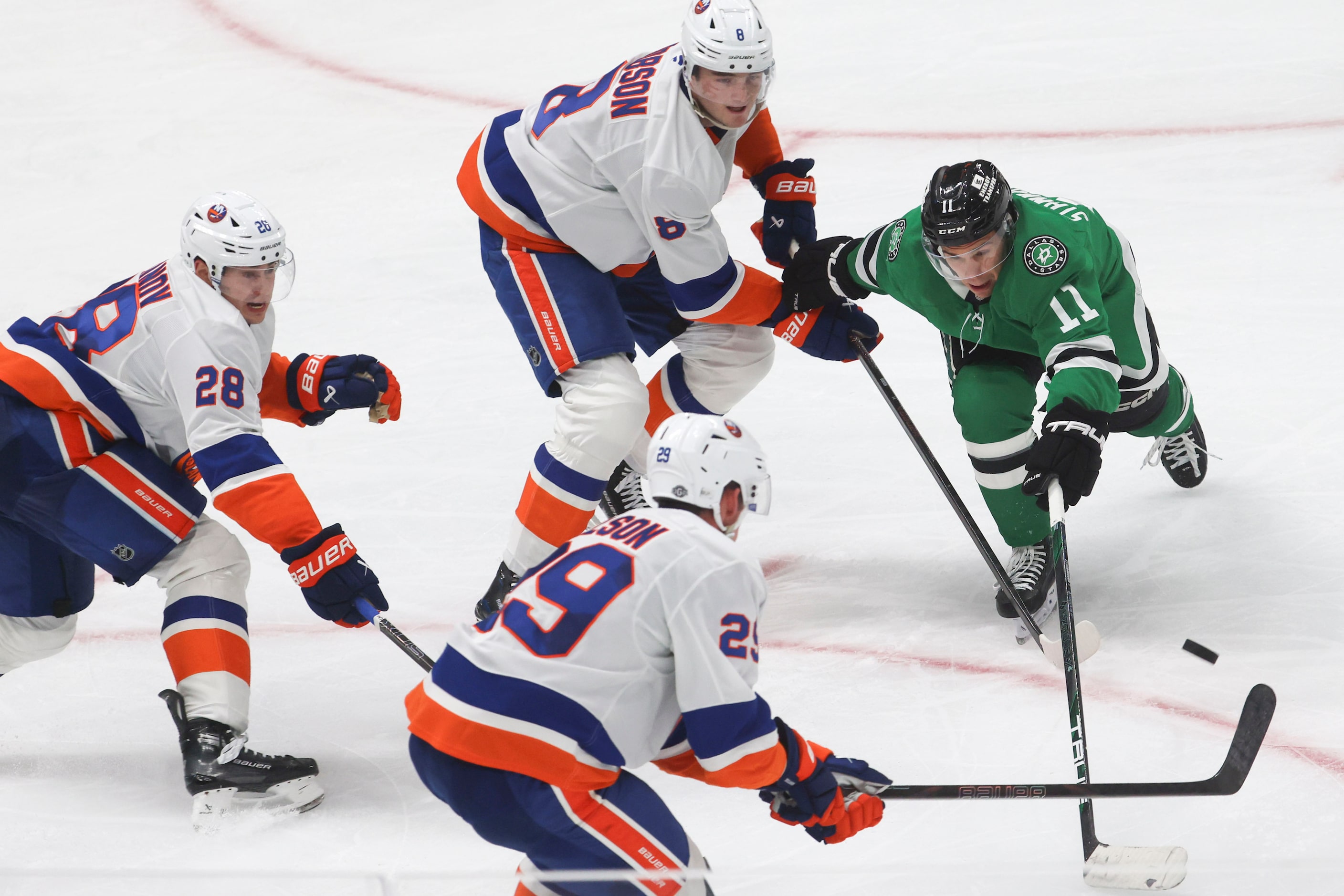 Dallas Stars center Logan Stankoven (11) reaches for a loose puck against New York Islanders...