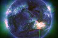 This image provided by NASA shows a solar flare -- the bright flash in the lower right --...