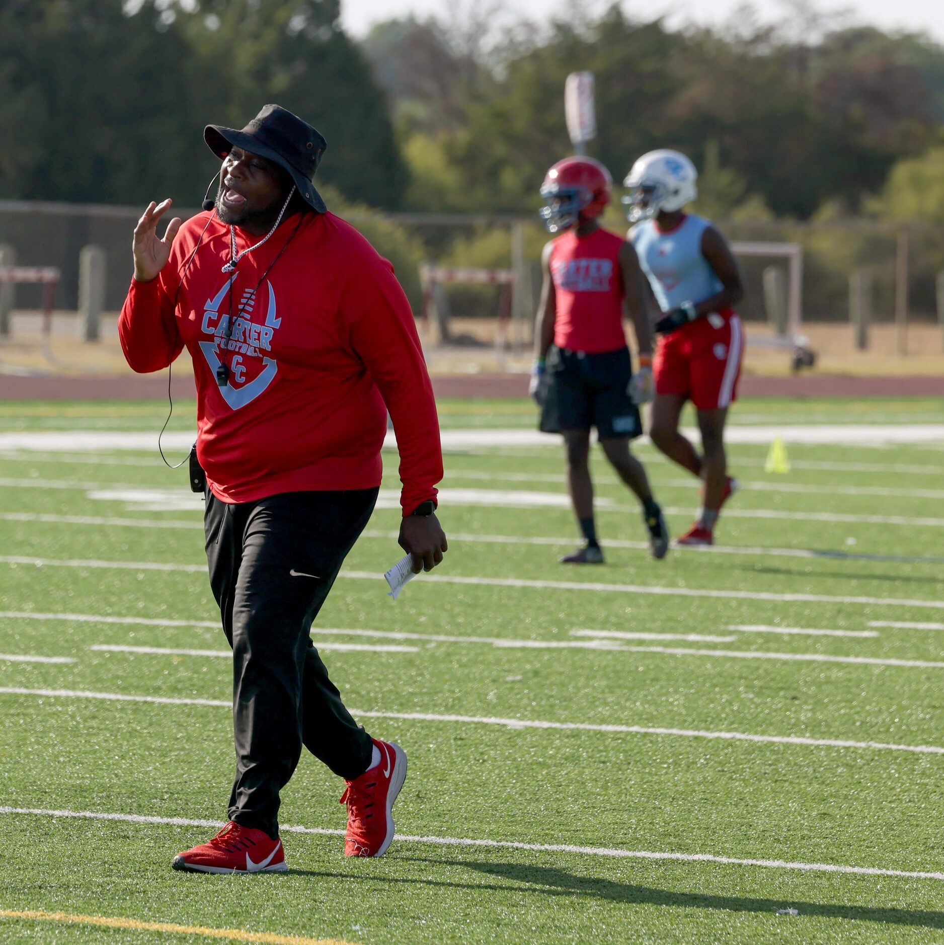 Head coach Spencer Gilbert explains a drill during the first football practice of the season...