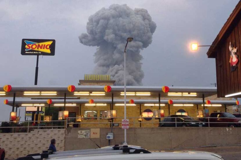 People at the popular Czech Stop watch a cloud of smoke rising from an explosion at the...