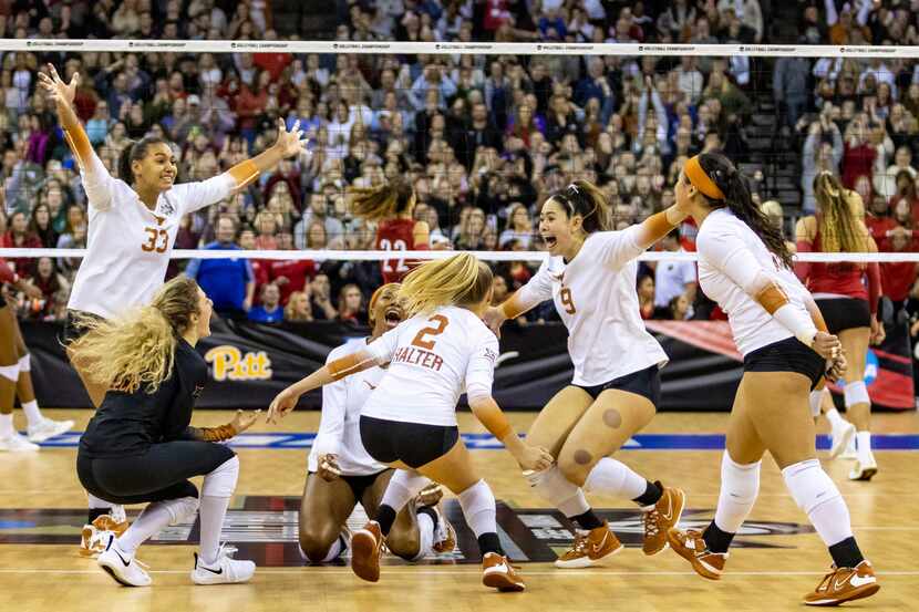 Texas celebrates a win over Louisville in the third set during the NCAA college volleyball...