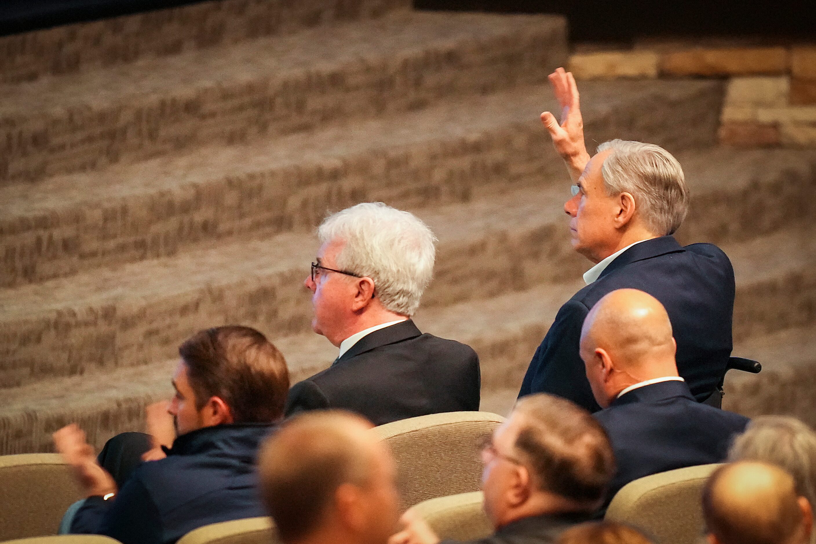 Texas Gov. Greg Abbott waves as he is acknowledged during for a vigil at Cottonwood Creek...