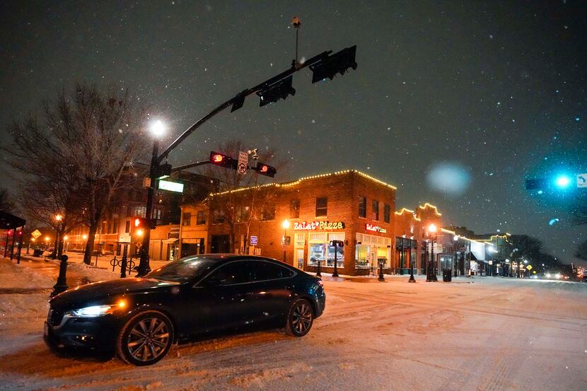 Cars move slowly through Historic Downtown Plano as a second winter storm brought more snow...