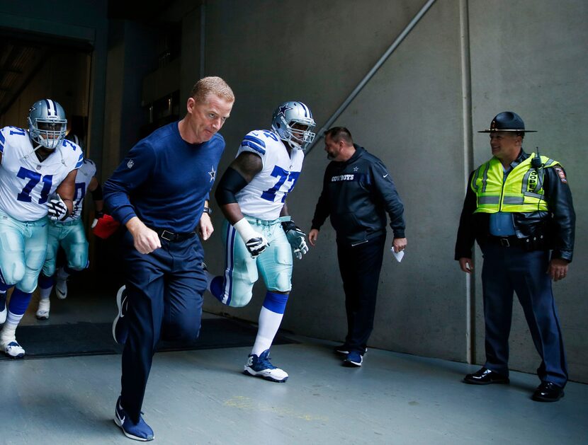 Dallas Cowboys head coach Jason Garrett and the Dallas Cowboys make their way on the field...