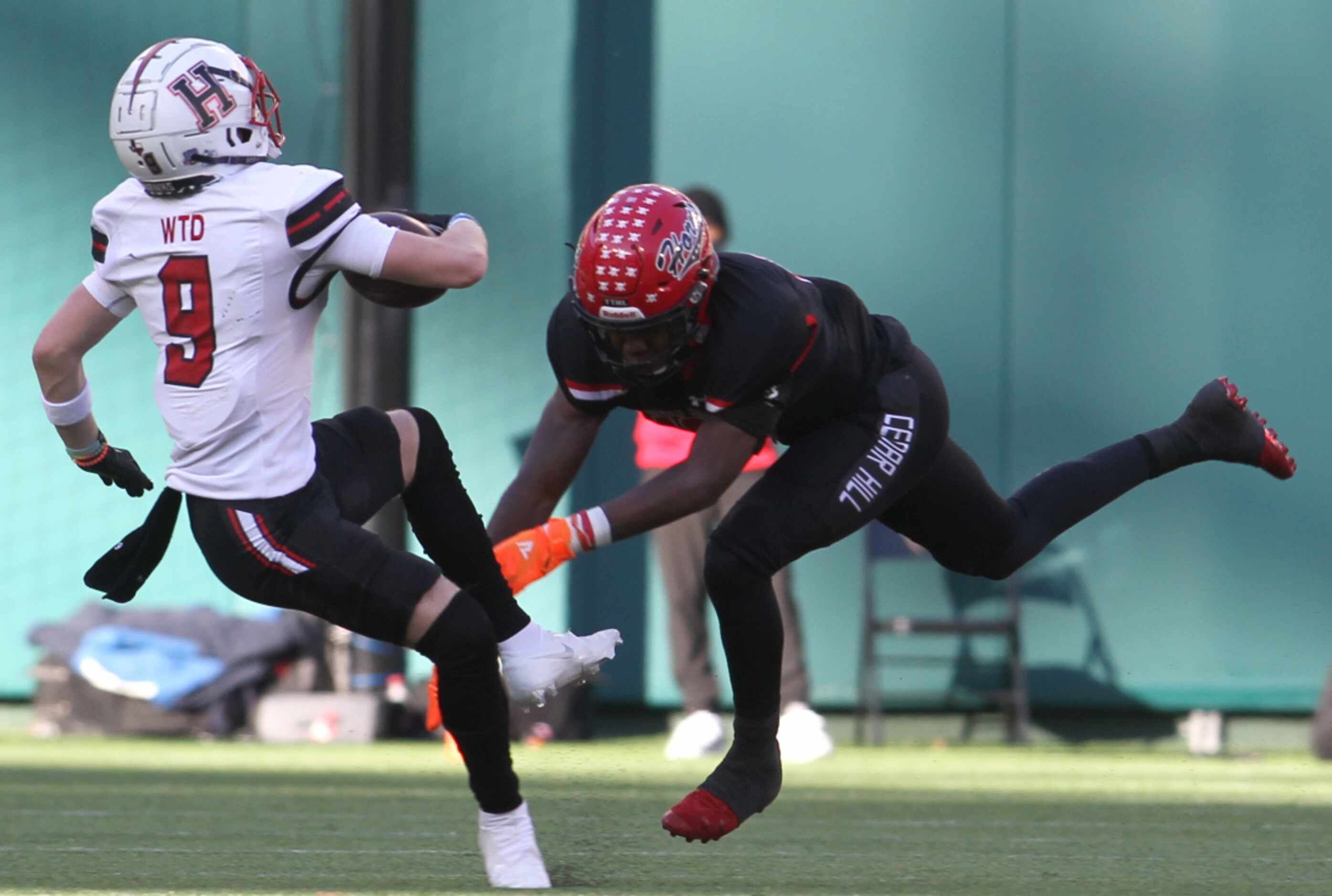 Rockwall Heath receiver Corban Cleveland (9) is tripped up by Cedar Hill linebacker Jaheim...