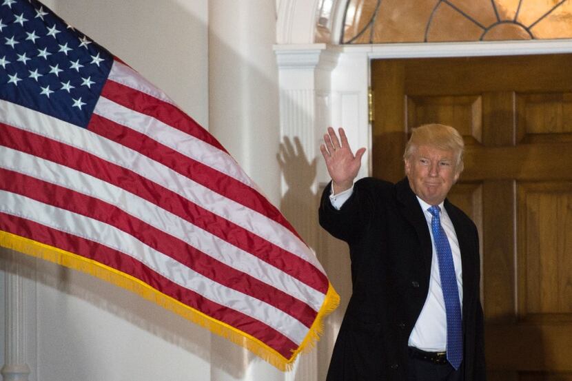 TOPSHOT - President-elect Donald Trump waves to the media from the steps at the clubhouse of...
