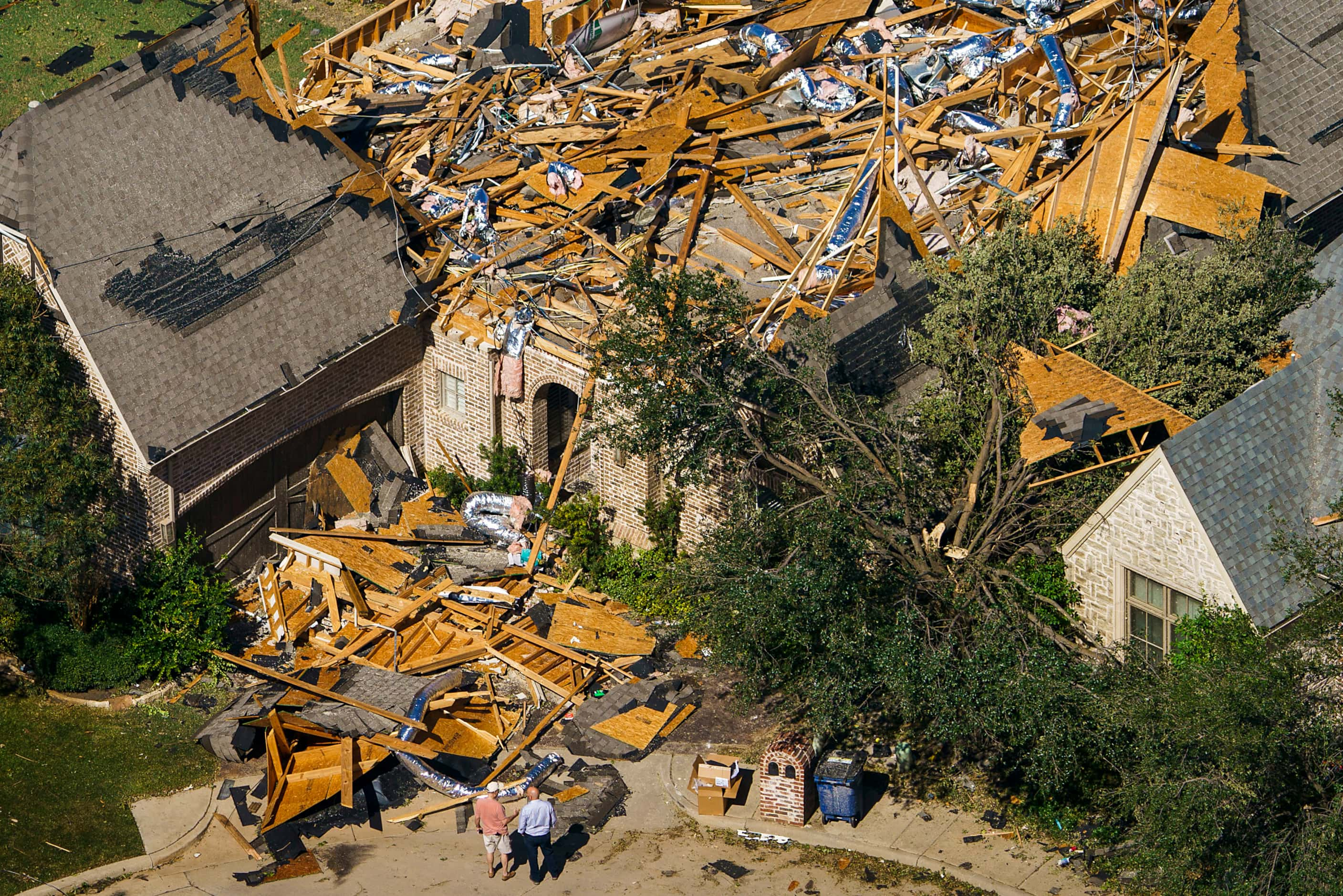 People survey tornado damage to a home near Walnut HIll Lane and Mash Lane on Monday, Oct....