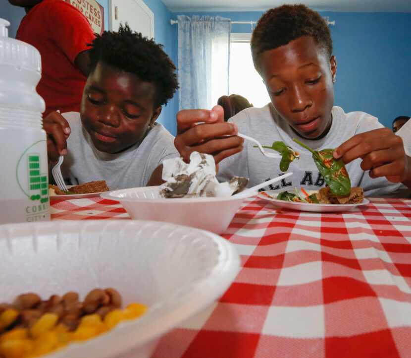 Javarius Norice (left), 13, and Brandon Chew ,13, eat a healthy lunch while visiting The...