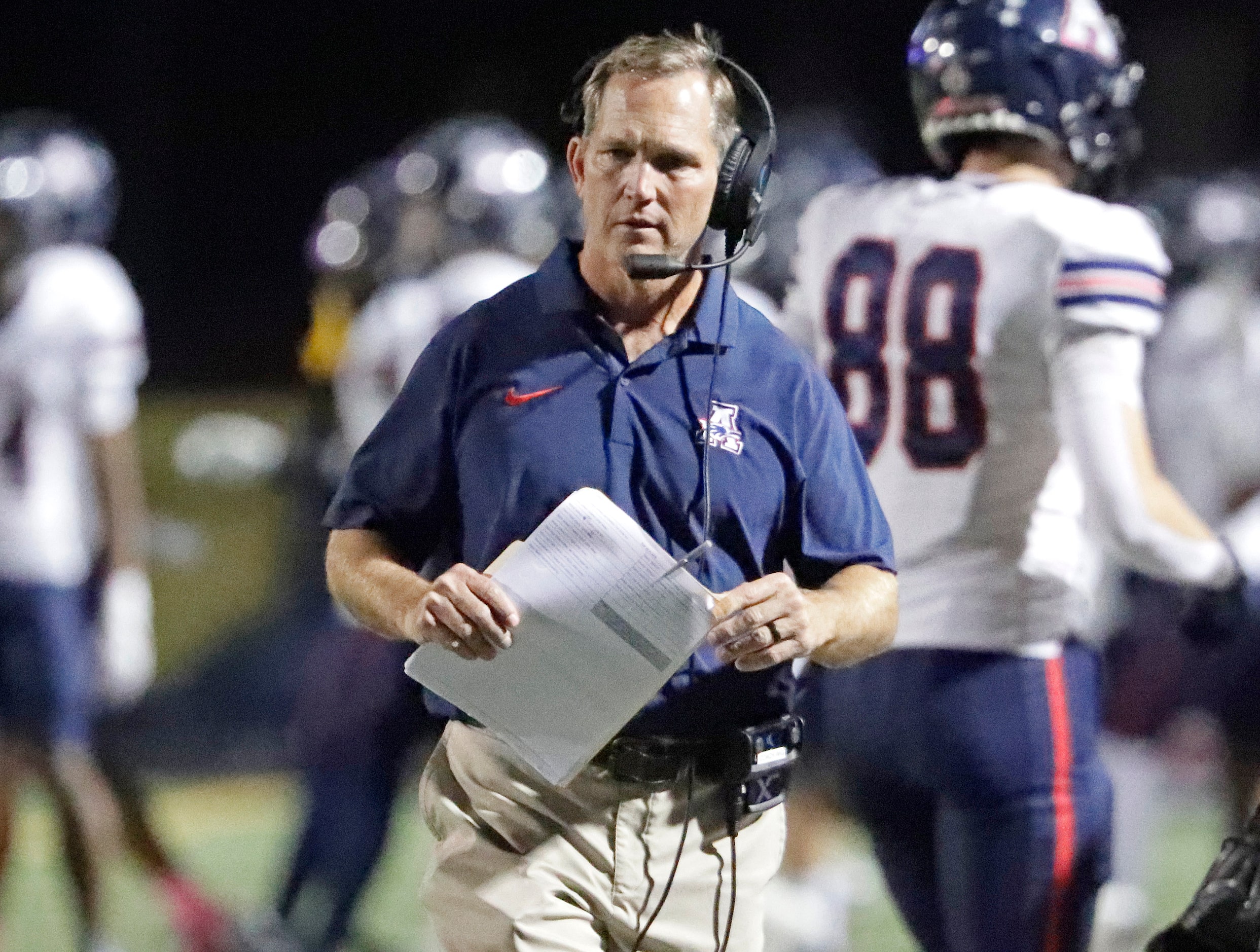 Allen High School head coach Lee Wiginton walks the sideline after his team scored during...