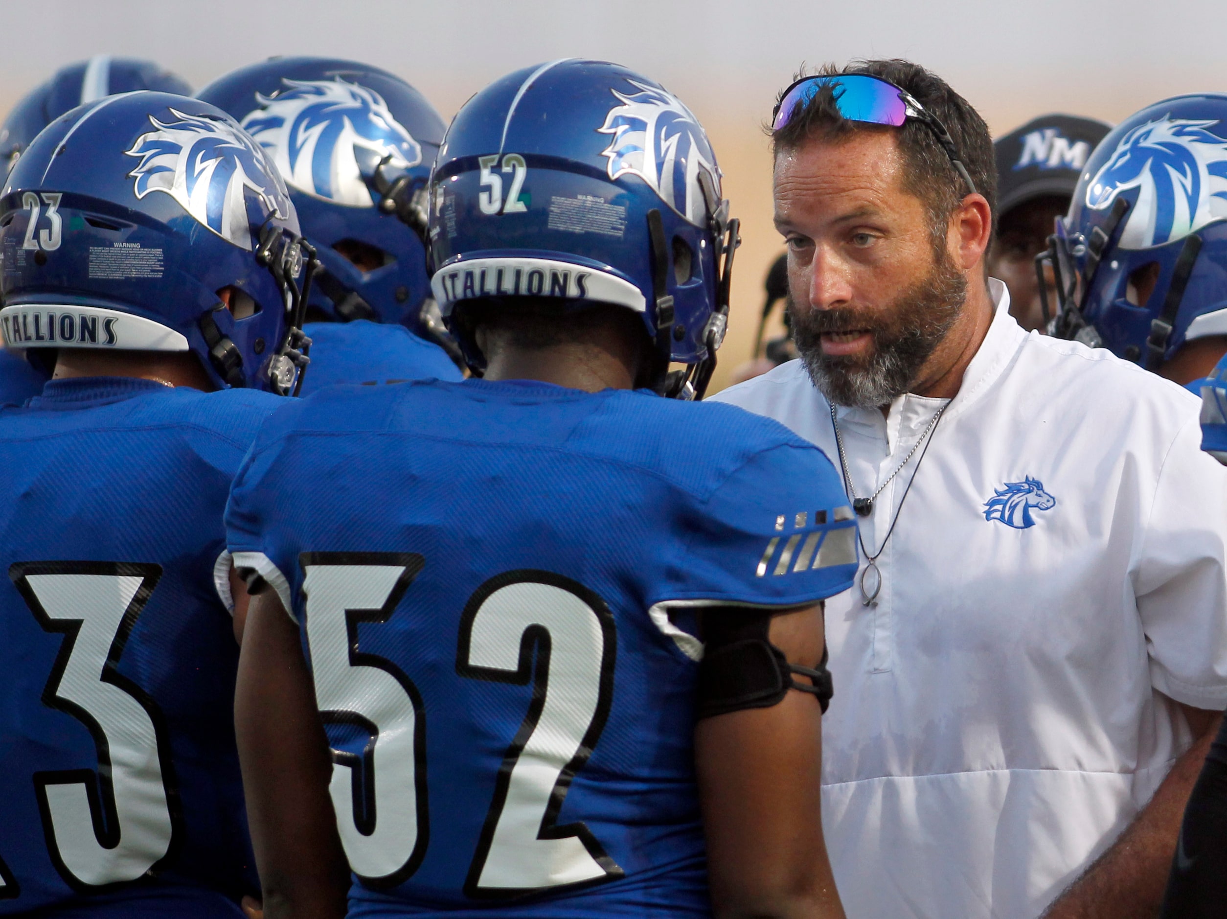 North Mesquite assistant coach David Lynch speaks with defensive lineman Rodney Hobbs (52)...