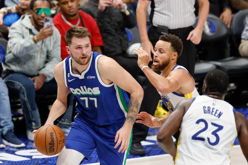 Dallas Mavericks guard Luka Doncic (77) dribbles around Golden State Warriors guard Stephen...