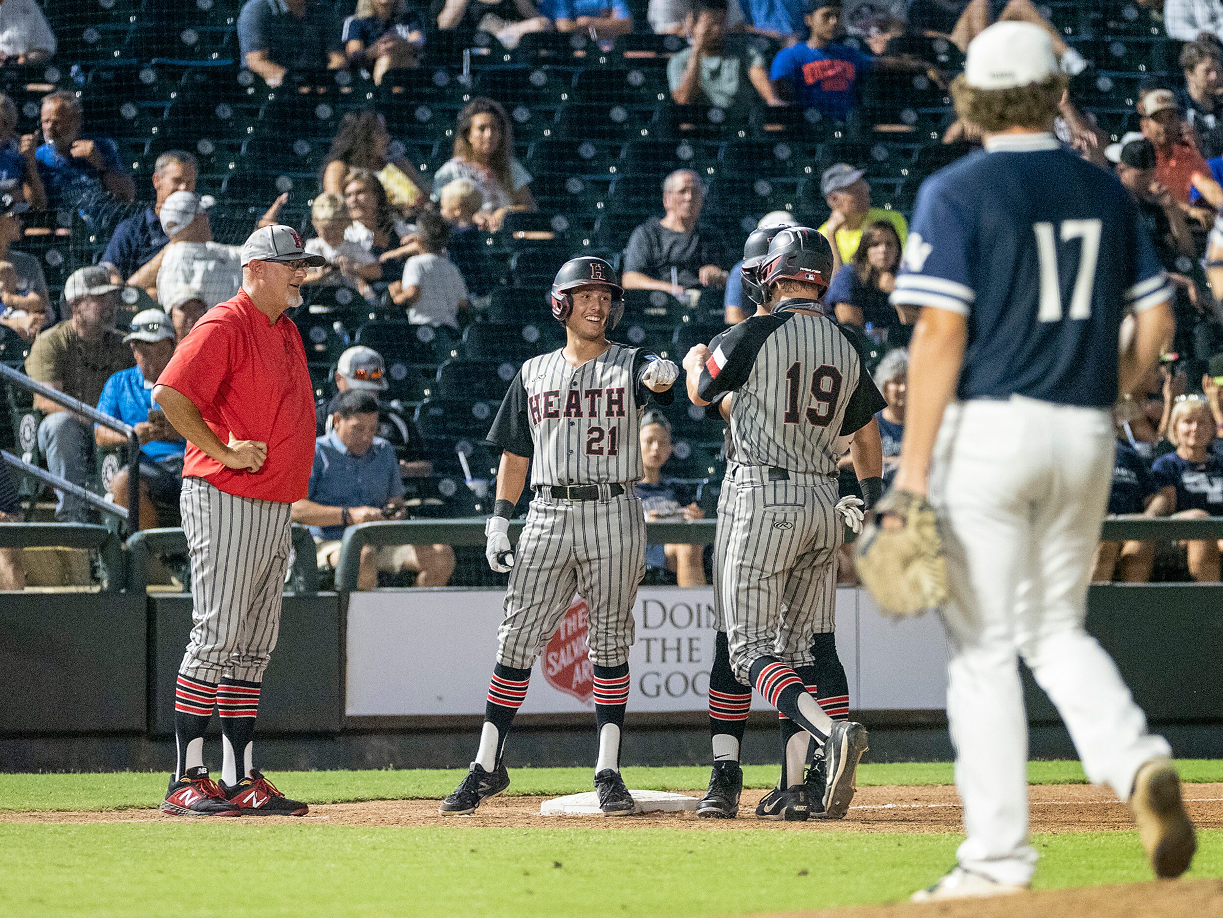 Rockwell-Heath Zach Rike, (21), fist bumps Zach Rike, (21), as Caleb Hoover, (7), behind,...