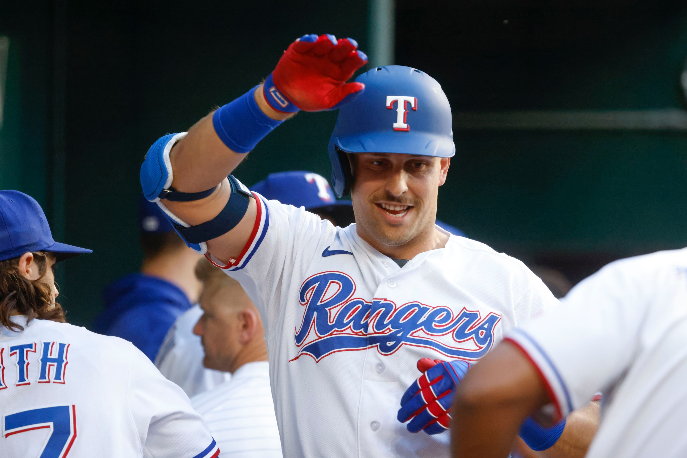 Texas Rangers first baseman Nathaniel Lowe high fives his teammates in the dugout after...