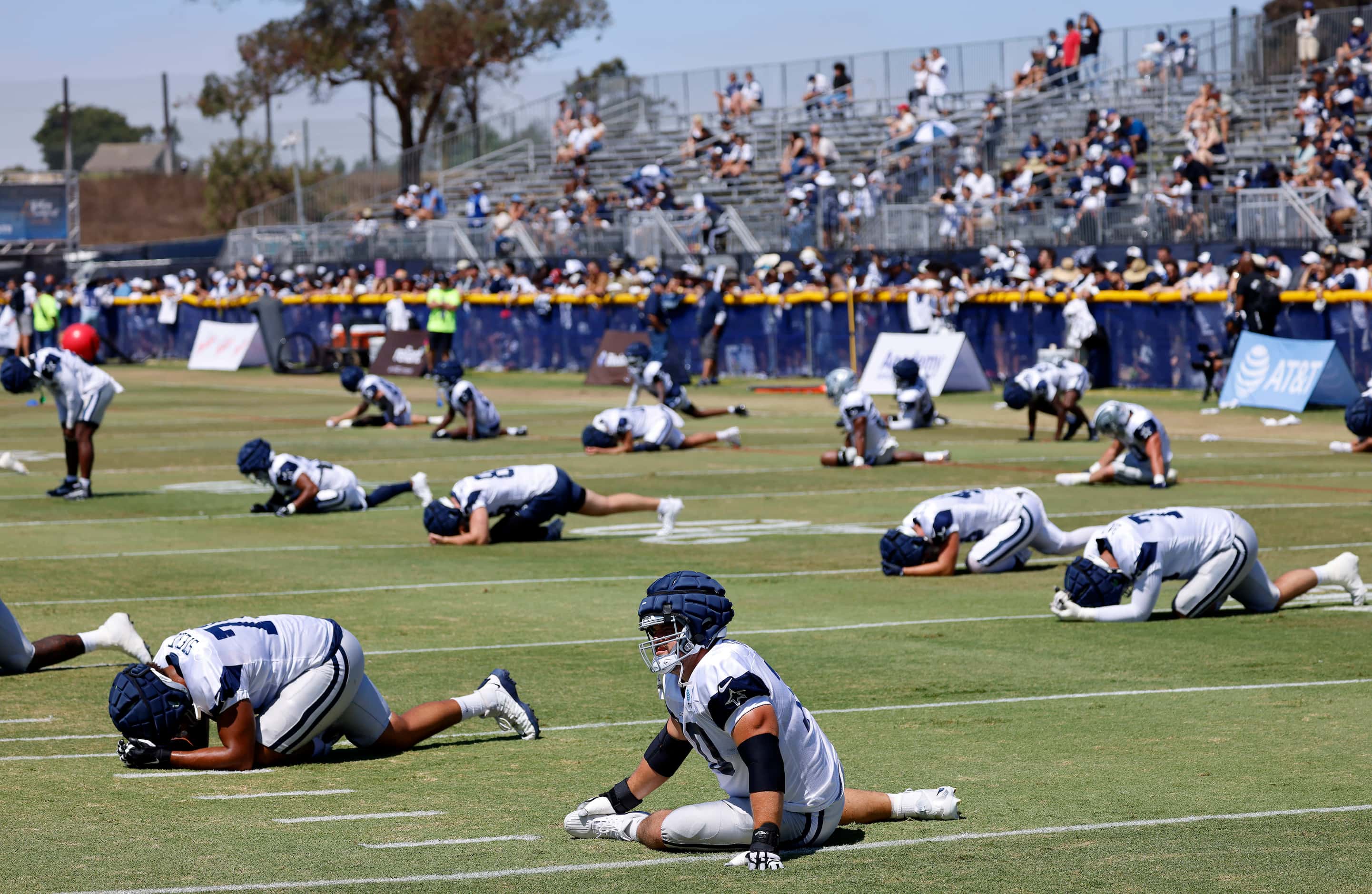 The Dallas Cowboys offense stretches before training camp practice begins in Oxnard,...
