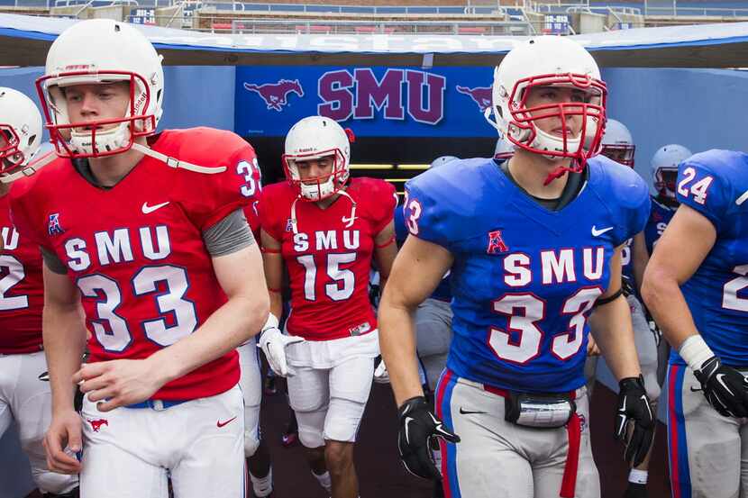 SMU punter Alex Melvin (red #33) and linebacker Matt McNew (blue #33) head to opposite...