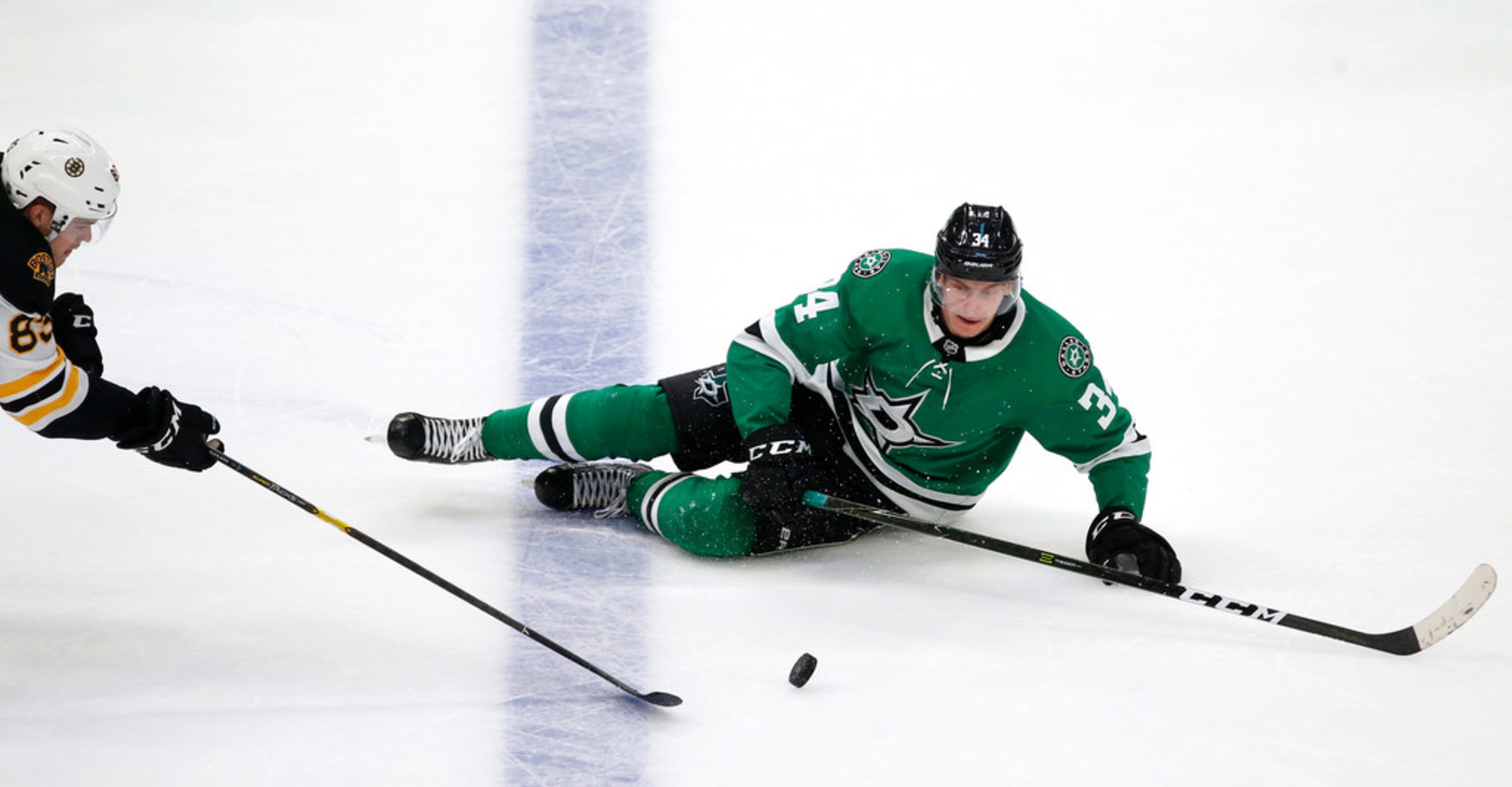 Dallas Stars right wing Denis Gurianov (34) falls as Boston Bruins center Karson Kuhlman...