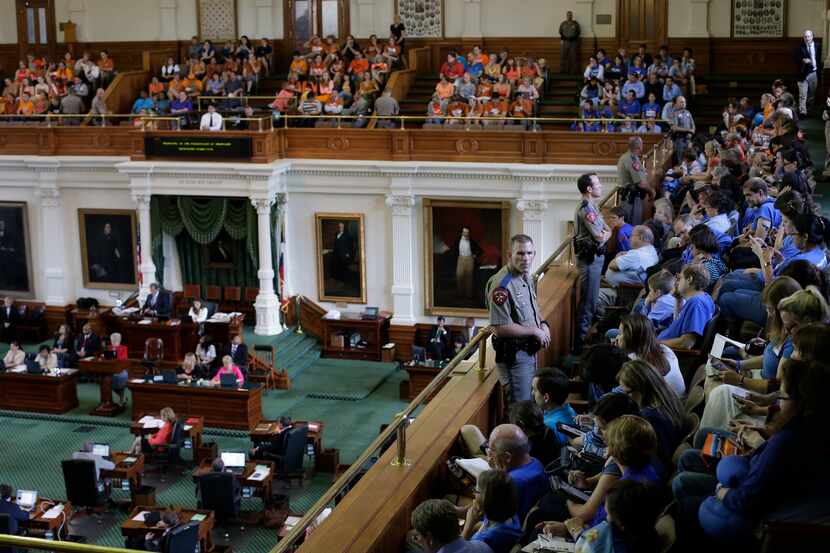 Texas state troopers keep watch as supporters and opponents of an abortion bill, mostly...