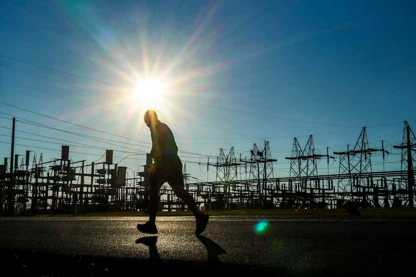 A runner passes the Oncor Cedar Hill Switchyard as the sun beats down in Dallas.