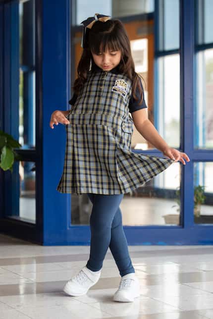First-grader Sarah Kadiwala shows off her new school uniform at Brighter Horizons Academy in...