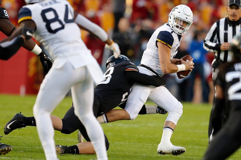West Virginia quarterback Will Grier, right, is sacked by Iowa State defensive end Spencer...