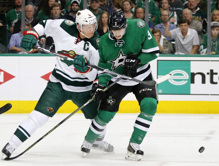 Dallas Stars defenseman John Klingberg (3) and Minnesota Wild center Mikko Koivu (9) battle...