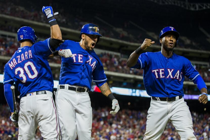 Texas Rangers center fielder Ian Desmond (20, center) celebrates a home run with right...
