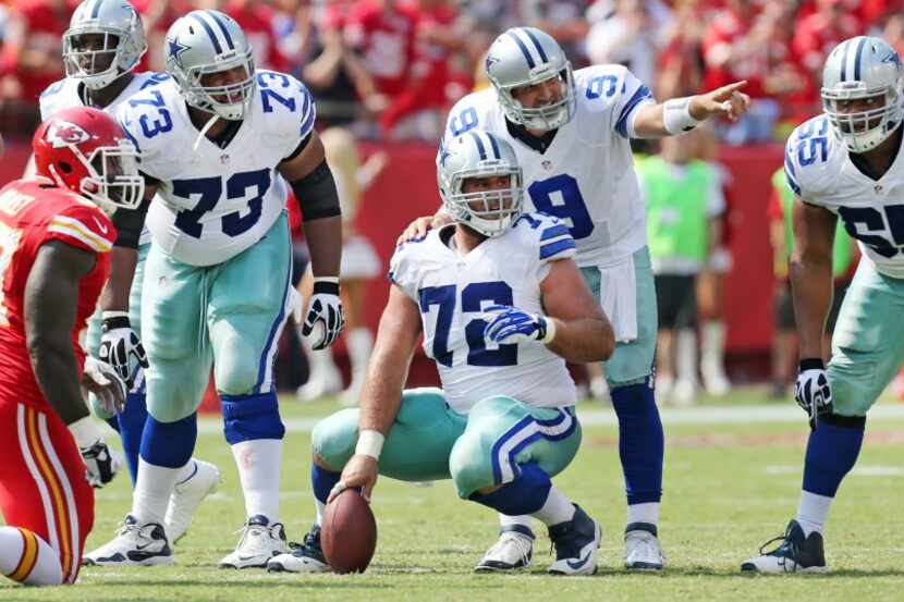 Dallas Cowboys quarterback Tony Romo (9) calls the signals as Dallas Cowboys guard Mackenzy...