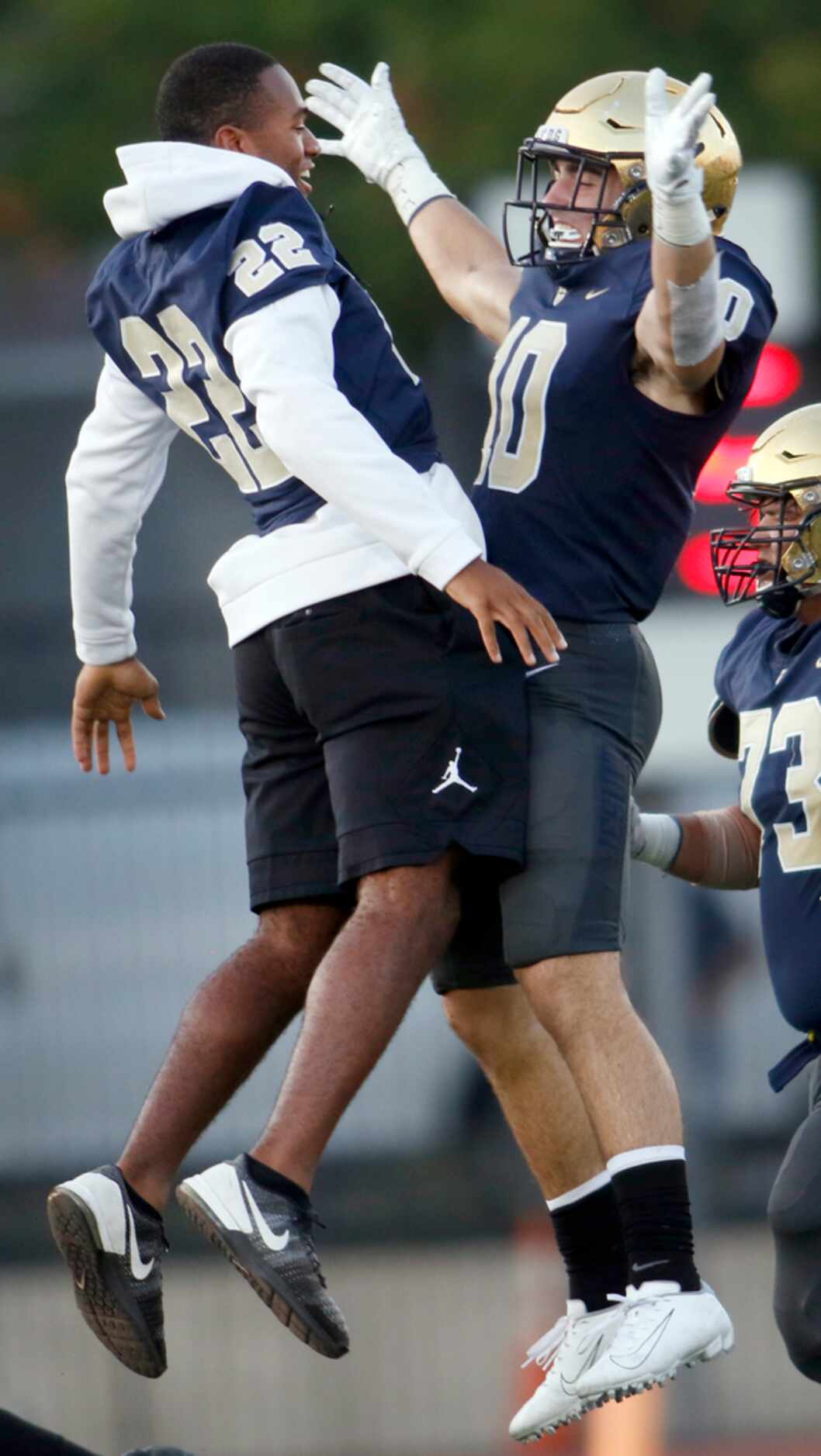 Jesuit running back E.J. Smith (22) leaps to celebrate kicker Mitchell Campbell's successful...