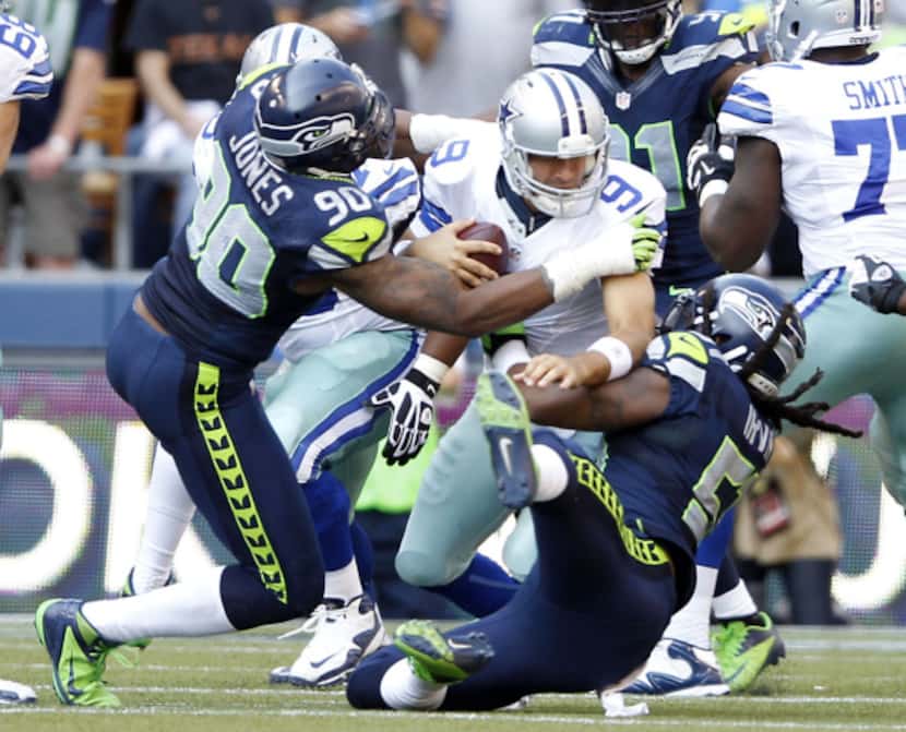 Dallas Cowboys quarterback Tony Romo (9) is sacked by Seattle Seahawks defensive end Jason...