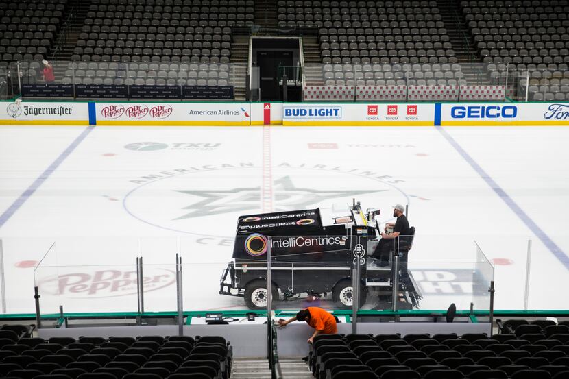 Crews clean and prepare to cover the Dallas Stars ice after the NHL season was put on hold...
