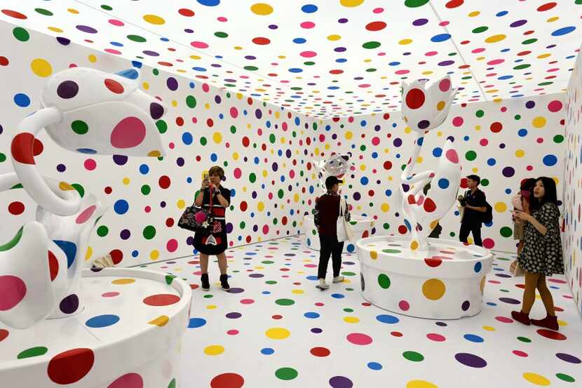 Visitors stood inside an installation by Japanese artist Yayoi Kusuma titled With All My...