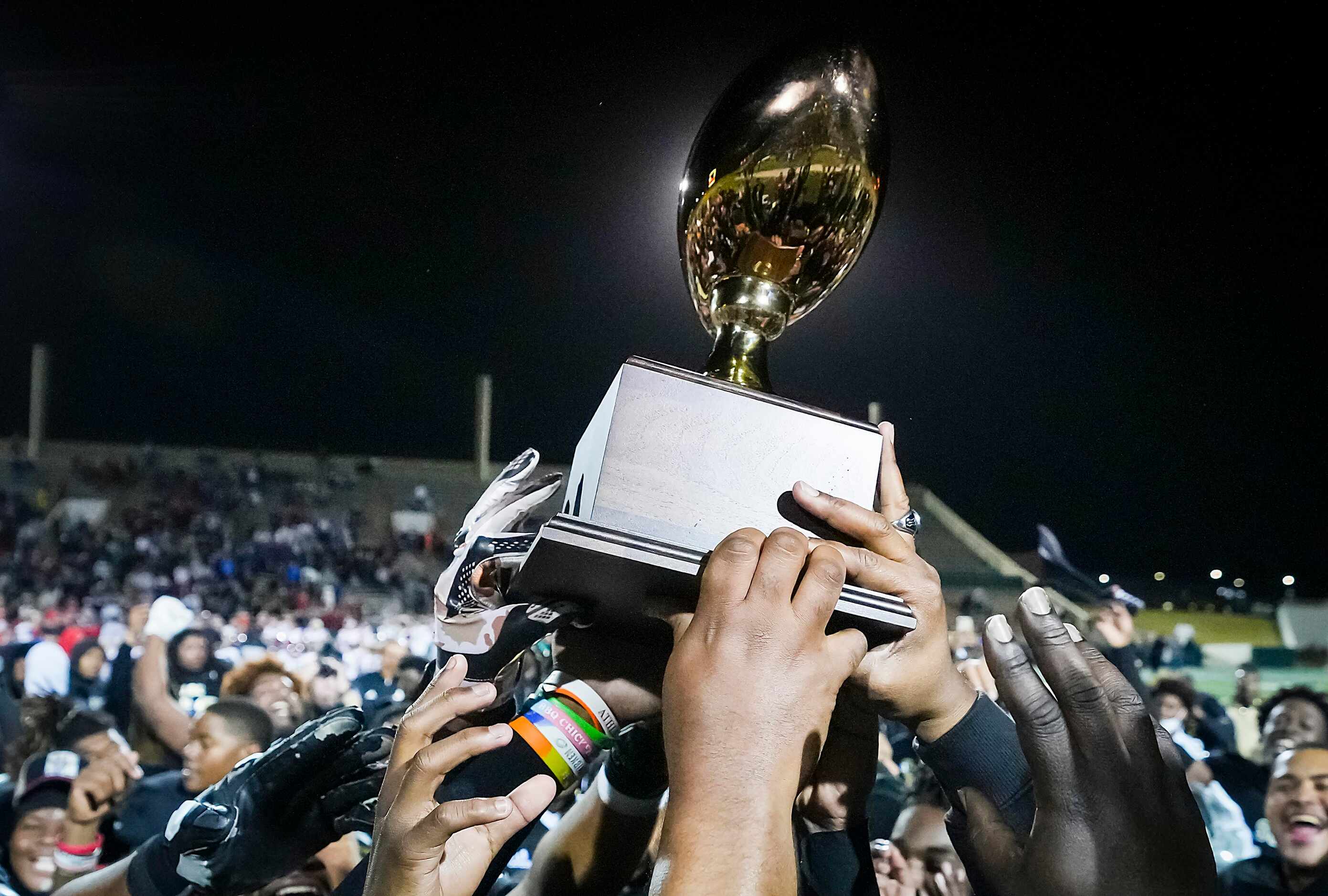 South Oak Cliff celebrate with the game trophy after a victory over Lubbock Cooper in a...