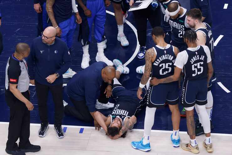 Dallas Mavericks center Dereck Lively II (2) holds his head after sustaining an injury...